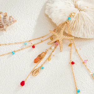 Close-up of gold multi-layer body chain featuring starfish, shells, and colorful beads.