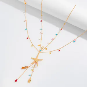 Detailed view of a multi-layer gold body chain featuring a starfish and colorful beads.