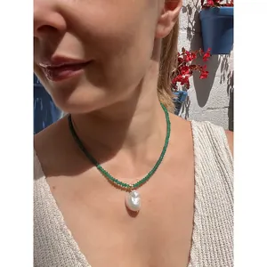 Λεπτομέρεια κολιέ με μπαρόκ μαργαριτάρι και πράσινες πολύπλευρες φυσικές πέτρες.