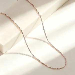 Close-up of a delicate rose gold titanium steel O-chain necklace with a soft glow