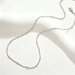 Close-up detail of a minimalist titanium steel satellite beaded chain necklace