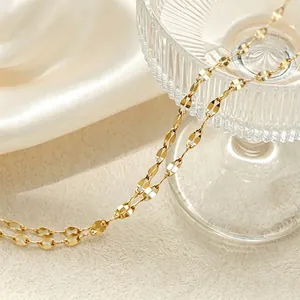 Close-up detail of a minimalist gold star-patterned stainless steel necklace chain.