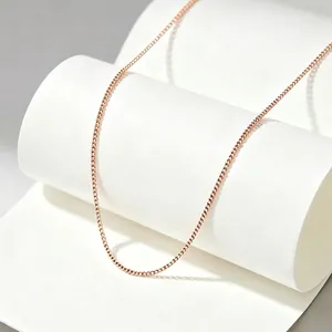 Close-up of a minimalist rose gold titanium steel fine chain necklace on a white stand