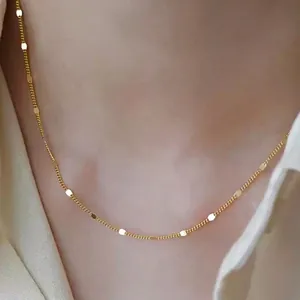 Close-up of a minimalist gold-plated titanium steel necklace on a model's neck
