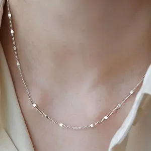 Close-up of minimalist titanium steel necklace with flat link details on neck skin.