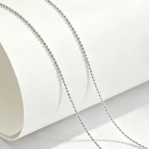 Close-up detail of silver titanium steel bead chain necklace with polished finish
