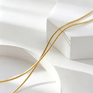 Close-up of a minimalist gold titanium steel snake chain necklace for women