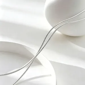 Close-up of sleek stainless steel snake chain necklace with high-polish silver finish