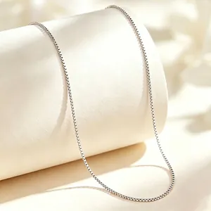 Close-up of minimalist titanium steel box chain necklace with smooth silver finish