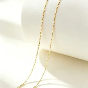 Detailed close-up of elegant gold-toned stainless steel lips chain necklace on stand.