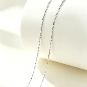 Close-up of a minimalist silver-colored sparkling stainless steel necklace chain.