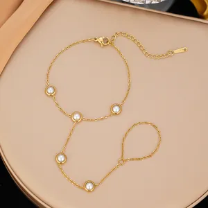 Elegante bracciale da mano in acciaio inossidabile dorato con cinque perle bianche rotonde.