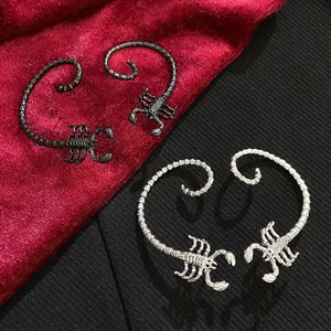 Detail shot of black and silver scorpion-shaped hand jewelry with intricate textures