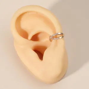 Close-up detail showing elegant gold-plated zircon cross hollow ear cuff on mannequin ear
