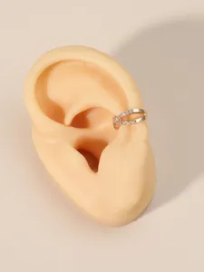 Detail view of gold-plated crossed ear cuff with sparkling zircon inlay on ear model
