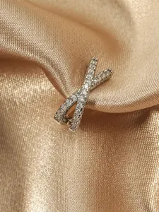 Close-up detail of an X-shaped cross ear cuff with pavé set cubic zirconia stones