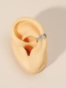 Detailed macro view of an elegant criss-cross zircon ear cuff displayed on an ear model