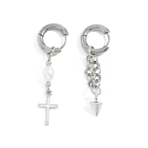 Close-up of asymmetrical silver hoop earrings with pearl cross and chain spike detail