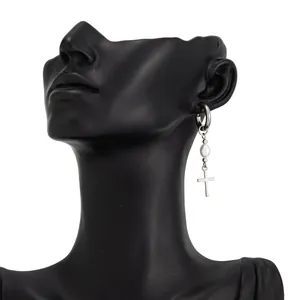 Close-up of silver ear cuff with pearl and cross pendant on a black mannequin.