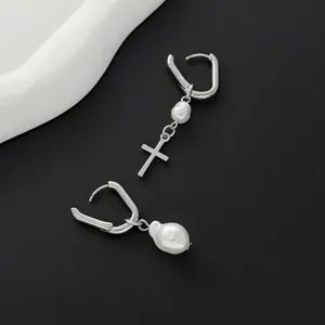 Detailed view of silver U-shaped hoop earrings with baroque pearl and cross pendant