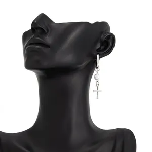 Macro view of silver cross earring with pearl accent worn on a black mannequin display head.