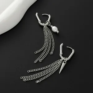 Close-up of stylish asymmetrical earrings featuring pearl and silver chain tassels