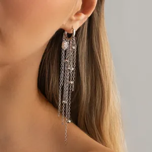 Detailed view of long silver chain tassel earrings with a pearl and beads