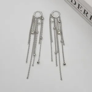 Detailed view of silver-tone tassel earrings featuring pearls and heart charms.