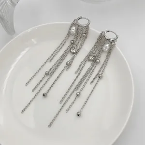 Detailed view of silver long chain tassel earrings with pearls and heart charms