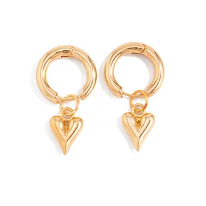 Close-up detail of stylish golden hoop earrings with polished heart-shaped dangles.