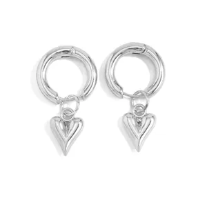 Close-up of silver-colored hoop earrings with solid 3D heart-shaped pendants