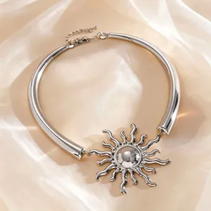 Primo piano dettagliato del ciondolo a forma di sole su una collana a girocollo in argento