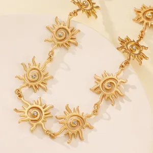 Vista macro dettagliata di una collana con ciondolo a sole in oro e cristalli