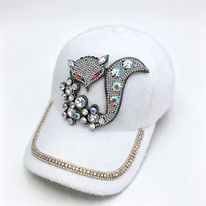 Gros plan du motif de renard en strass étincelants sur une casquette d'hiver blanche
