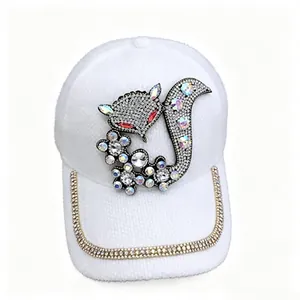 Détail d'une casquette en velours blanc avec un motif de renard en strass brillants