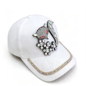 Détail d'une casquette en velours de vison blanc avec renard en strass et bord brillant