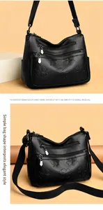 Sac bandoulière en cuir noir avec motifs trèfle embossés et poches zippées