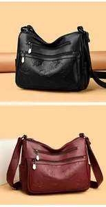 Détail montrant le motif trèfle embossé et les fermetures éclair du sac bandoulière.