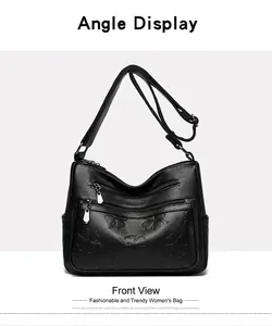 Vue de face d'un sac bandoulière en cuir noir avec motifs trèfles à quatre feuilles