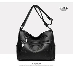 Vue détaillée d'un sac à bandoulière noir avec motif trèfle et texture de cuir grainé