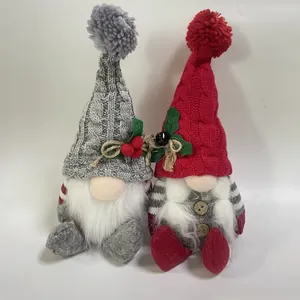 Detailopname van twee rood-grijze gebreide kerstkabouters met pluche baard