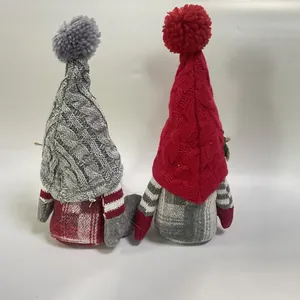 Gedetailleerd achteraanzicht van twee kerstkabouters met rood-grijs gebreide mutsen