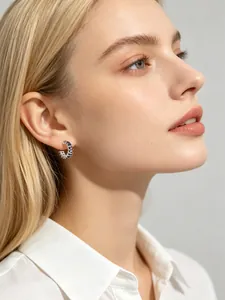 Close-up of S925 silver hoop earring with black square zircons worn by a model