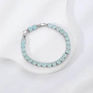 Elegant silver-toned bracelet featuring round light blue gemstones on a white jewelry stand
