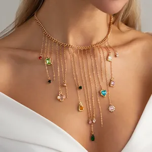 Elegant gold tassel necklace with multi-colored gemstone charms shown on a model