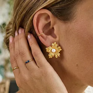 Gros plan détaillé d'une boucle d'oreille fleur dorée vintage avec perle centrale
