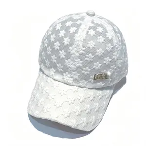 Détail d'une casquette de baseball en dentelle florale avec un emblème LOVE en strass