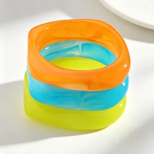 Set of retro translucent irregular resin bangles in vibrant orange, blue and green colors.