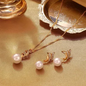 Elegant pearl and cubic zirconia jewelry set with gold necklace and matching earrings.