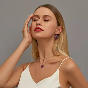Detail of elegant gold double-layered butterfly necklace and earrings set on model